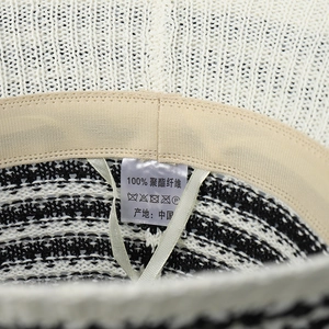 Macro shot of striped knit bucket hat interior with 100% polyester label and sweatband