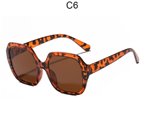 Detail view of tortoiseshell oversized sunglasses frame with brown lenses and metal hinge
