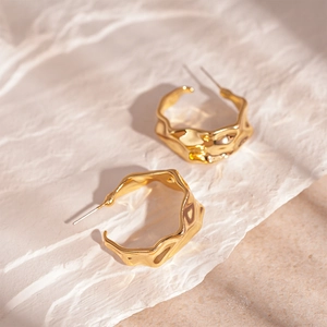 Minimalist golden C-shape hoop earrings with vintage wavy texture and metallic finish