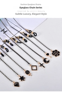 Detail view of black and gold eyewear chain charms including camellia and star pendants