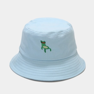 Close-up of green frog embroidery and stitching detail on blue cotton bucket hat