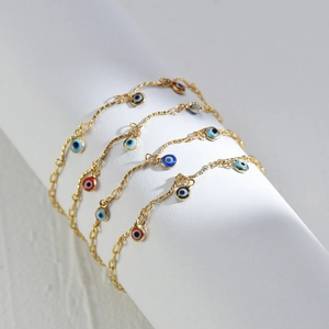 Detailed macro view of 14K gold-plated beaded tassel bracelets with colorful enamel charms