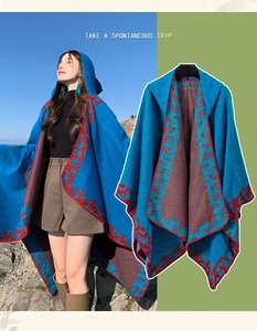 Detail of blue bohemian hooded poncho with red jacquard trim and knitted texture