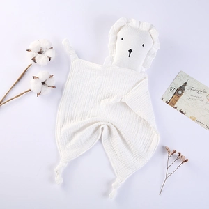 Detail of soft white cotton lion security blanket with knotted ends and lace trim for babies