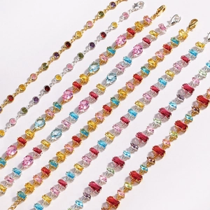 Close-up of colorful zircon bracelets with various gemstone cuts and gold and silver settings
