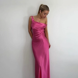 Détail du tissu en satin rose vif sur une robe d'été longue à une épaule dénudée