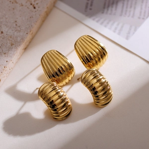 Detail of 18k gold plated drop and hoop earrings with textured metallic finish