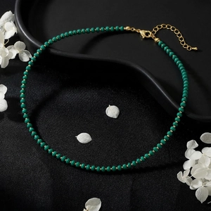 Detail of emerald green beaded necklace with gold spacers and adjustable lobster clasp closure