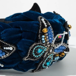 Detail of velvet braided headband with intricate blue beaded and pearl butterfly embroidery
