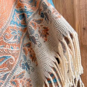 Close-up of paisley pattern polyester-cotton scarf with beige fringe details