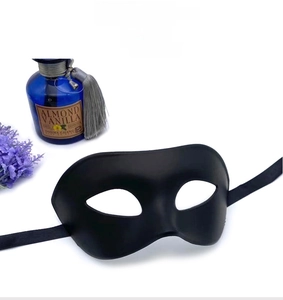 Detail of matte black masquerade mask with satin ribbons on a white background