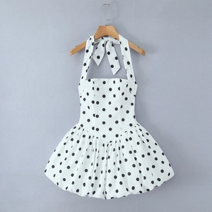 Détails de la robe dos nu blanche à pois noirs avec un corsage à lacets et jupe plissée