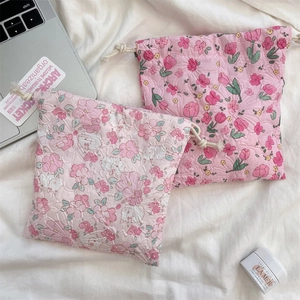 Close-up of pink floral seersucker drawstring storage bags with textured bubble fabric