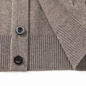 Detail of ribbed hem and texture of a brown knitted cardigan vest for men