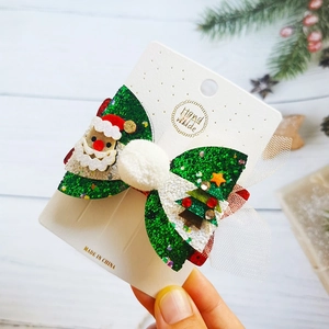 Detail of Christmas green sequin bow hair clip with Santa Claus and white pom-pom