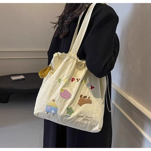 Detailed close-up of beige canvas tote bag featuring cute puppy and floral embroidery