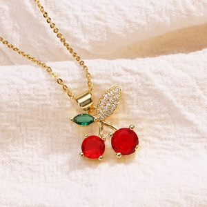 Minimalist gold necklace with red crystal cherry pendant and sparkling leaf detail