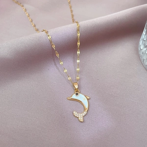 Detail of dolphin pendant with white enamel and micro-pave zircons on a gold chain