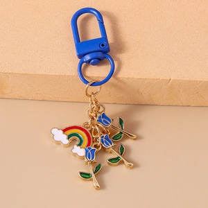 Detail of colorful rainbow cloud and blue tulip pendants on a gold chain keychain