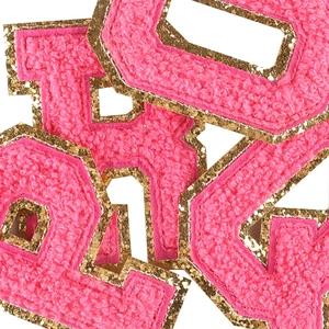 Pink chenille towel embroidered alphabet patch with gold glitter borders on white