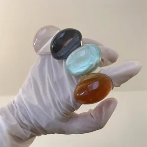 Set of four glossy oval resin rings in transparent white black mint and amber finishes