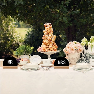 Rustic wooden wedding table signs with Mr and Mrs lettering on a floral outdoor setting