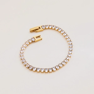 Detailed macro view of gold-plated tennis bracelet with oval-cut cubic zirconia stones