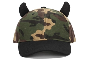 Detail of camouflage baseball cap featuring 3D black horns on top and a sleek black brim