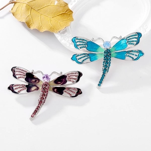 Elegant dragonfly brooches with enamel wings and rhinestones on a minimalist white base