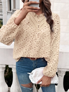 Detail of apricot embroidered hollow-out blouse with V-neckline and ruffle collar accents