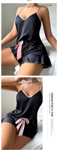 Vue détaillée du pyjama en satin noir avec bordures roses et nœud décoratif