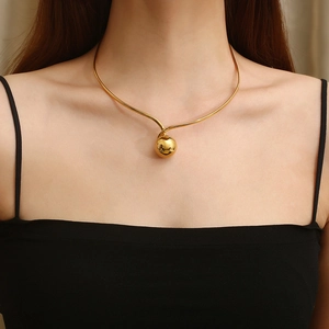 Gold spherical pendant choker necklace made of smooth stainless steel on female model