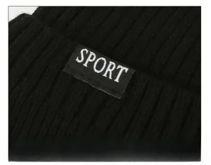 Close-up of black ribbed knit beanie featuring a white Sport label with detailed stitching