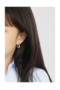 Primo piano di orecchini a goccia in oro minimalisti indossati da una modella