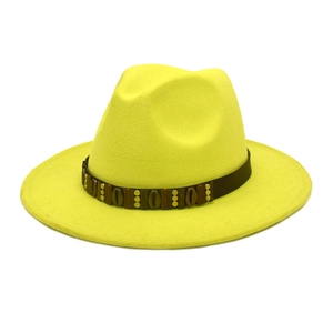 Detail of yellow wool fedora hat featuring a vintage brown band with gold metal studs