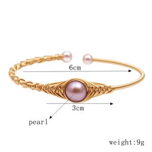 Macro shot of gold wire-wrapped bracelet with pink freshwater pearls and size dimensions