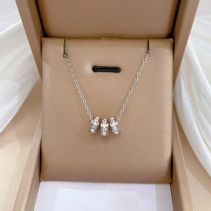 Minimalist titanium steel necklace with triple ring diamond pendants on beige gift box