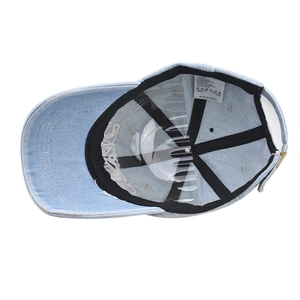Detail view of cotton baseball cap interior featuring black sweatband and adjustable metal buckle