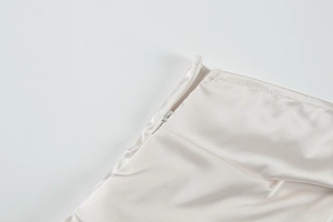 Close-up of invisible zipper and premium satin fabric on champagne mini dress