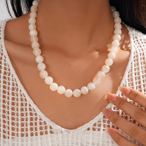 Close-up of white geometric acrylic beaded necklace with vintage marble effect