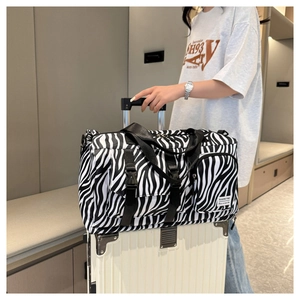 Detail of zebra print travel bag with back sleeve attached to a white suitcase handle