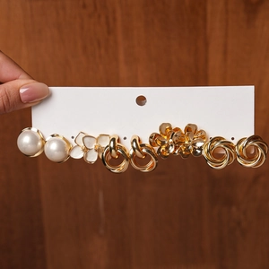 Detailed close-up of a 10-piece gold plated earring set featuring pearls and floral motifs