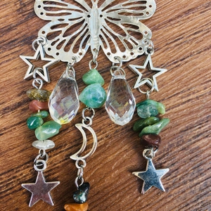 Detail of silver butterfly suncatcher with crystal ball and colorful natural crushed stones