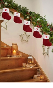 Detailed close-up of red knit Christmas stockings with white cuffs on a wooden staircase