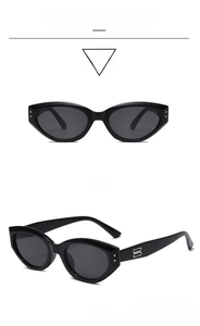 Detail view of retro cat eye sunglasses with glossy black frames and silver logo accents