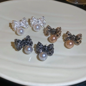 Trois paires de boucles d'oreilles nœud et perle avec textures métalliques variées