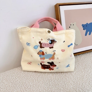 Gros plan du sac en velours côtelé avec broderie de chien et anses roses
