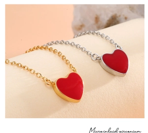 Macro shot of red heart pendant necklace featuring micro-inlaid zirconium and dual tone chain