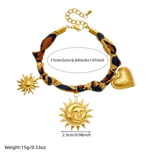 Gold stainless steel bracelet featuring leopard print ribbon and sun heart pendants
