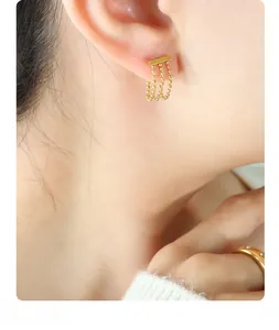 Close-up of triple-layered gold bead chain tassel earrings on a model with elegant finish